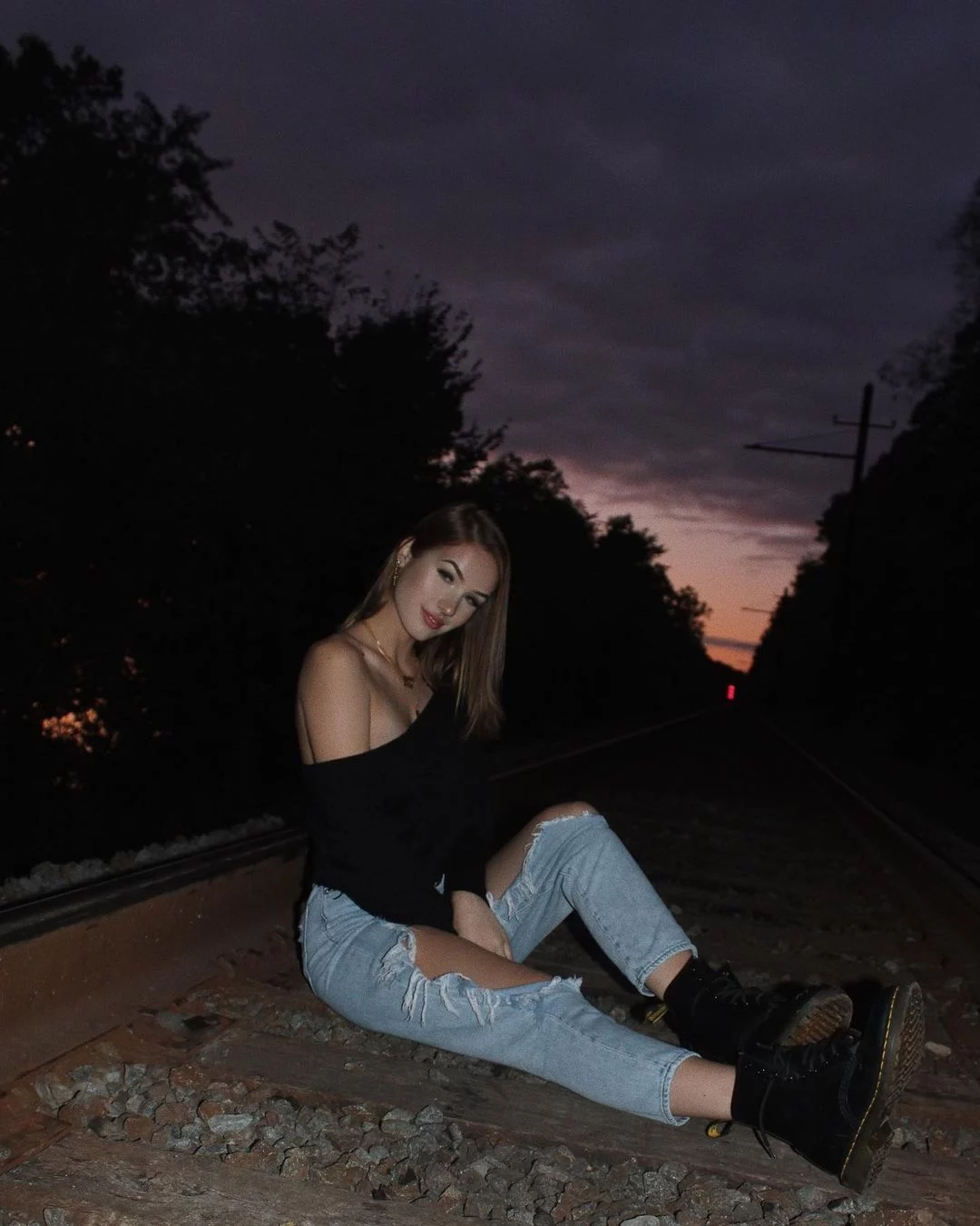 Skylar Bri sitting on a railway track
