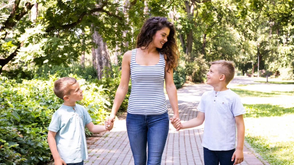 Mother walking in a park with two son