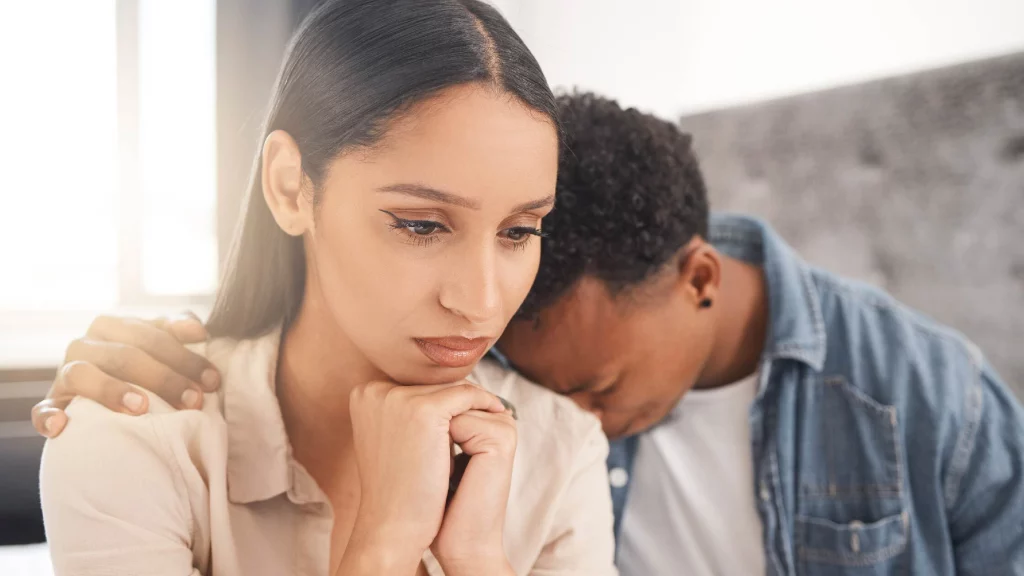 Boy crying keeping his head on his girl's shoulder