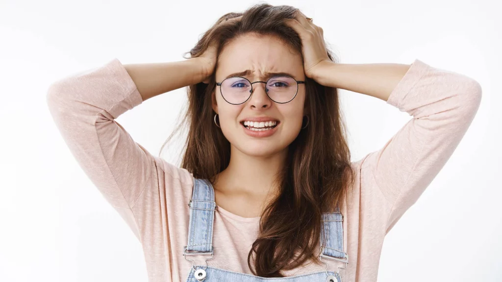 a girl wearing specs thinking holding her head