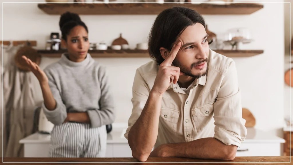 woman talking to a man and he is busy looking outside.