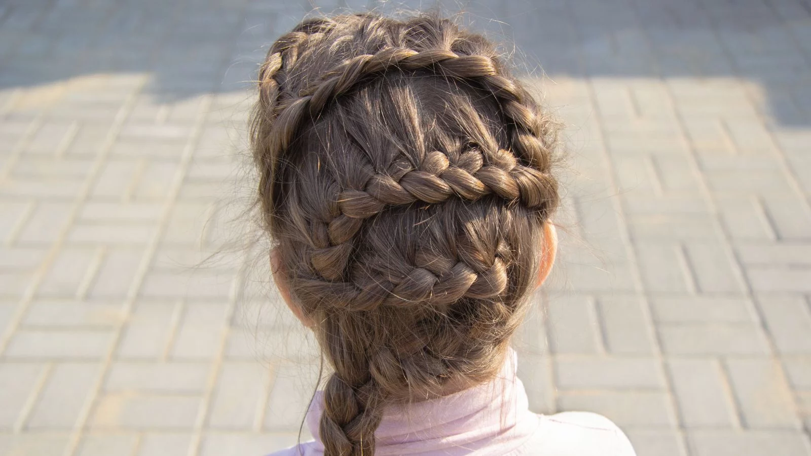Back images of a girl with criss-cross braids. 