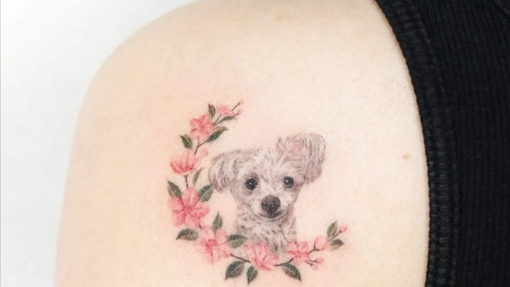 a little pup tattoo with flowers on back shoulder