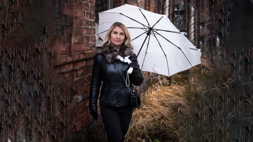 a women in black jacket holding an umbrella