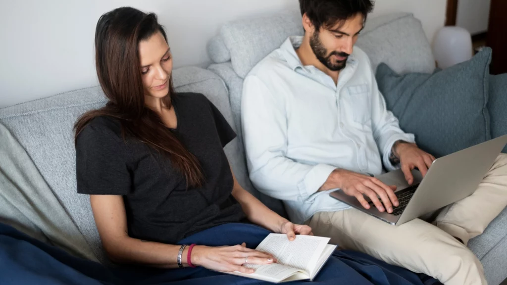 girl reading and boy using laptop