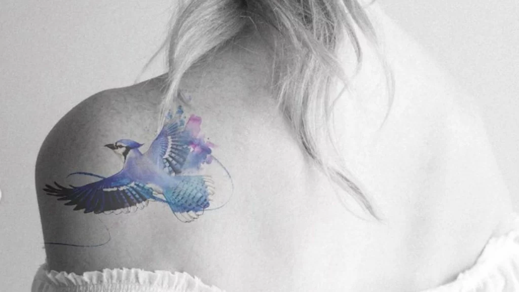 A blue bird tattoo on back shoulder