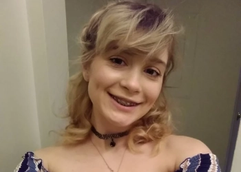 Anastasia Knight wearing a blue striped off shoulder top and is taking a selfie.