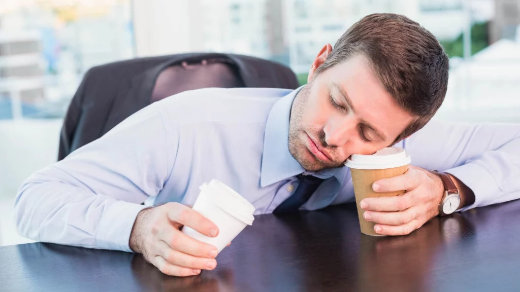 A man taking a nap in office.