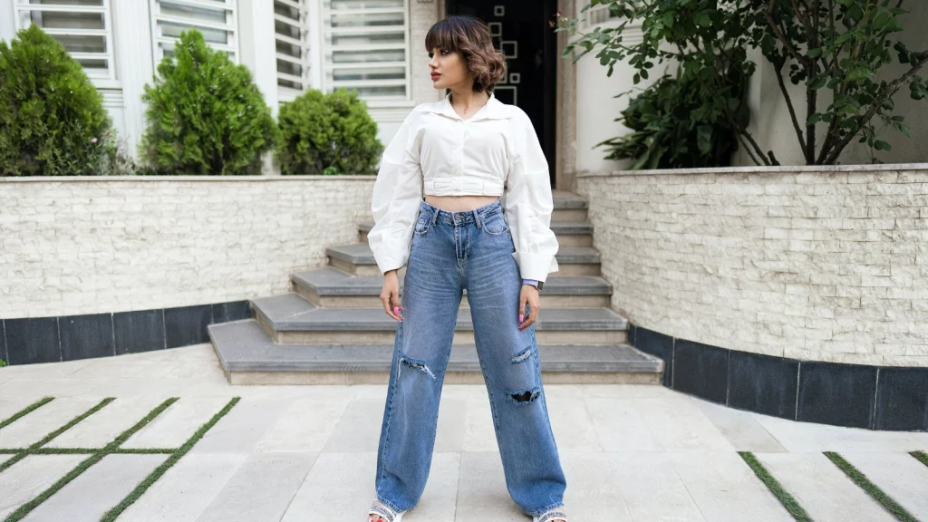 girl in white top and blue wide leg jeans