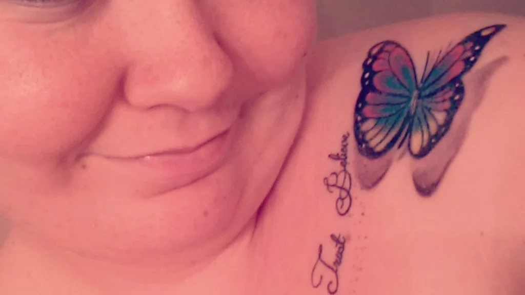 colored butterfly tattoo on front side of shoulder