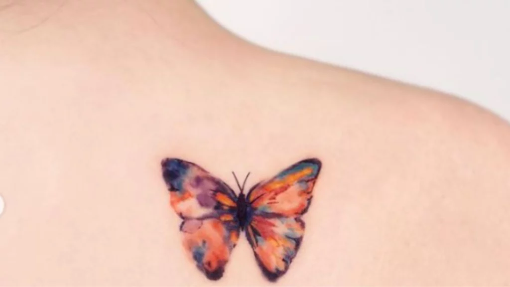colored butterfly tattoo on back shoulder