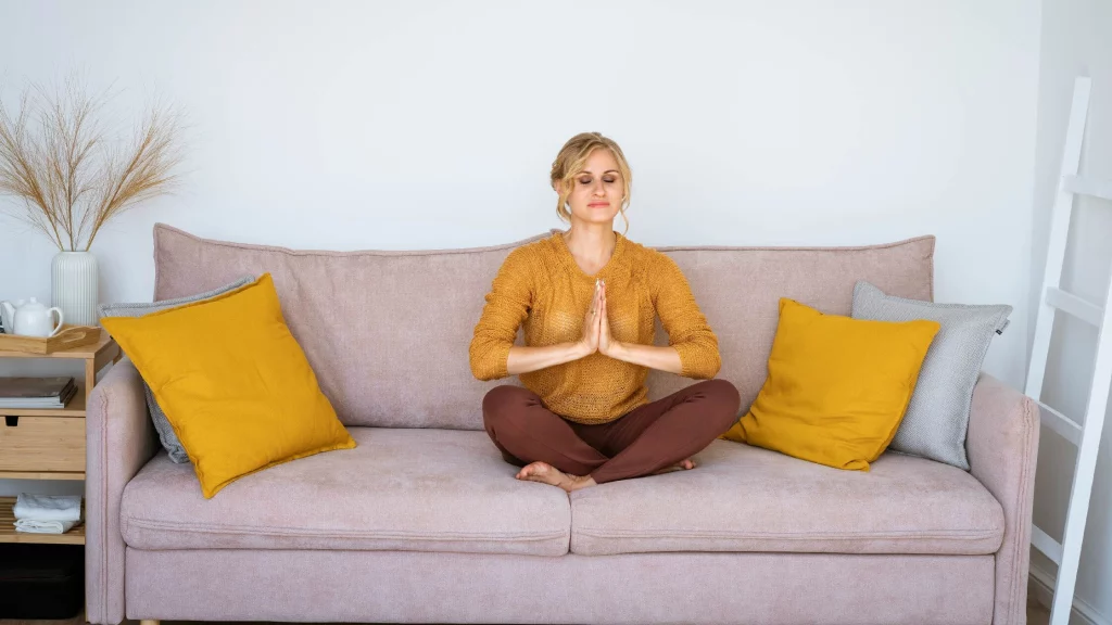 a girl doing breathing exercises on a sofa