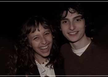 Elsie Pearls and Finn Wolfhard smiling and posing together.