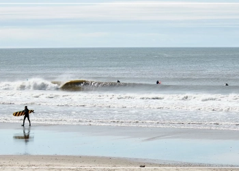 People surfing amongst the waves on a NY beach.