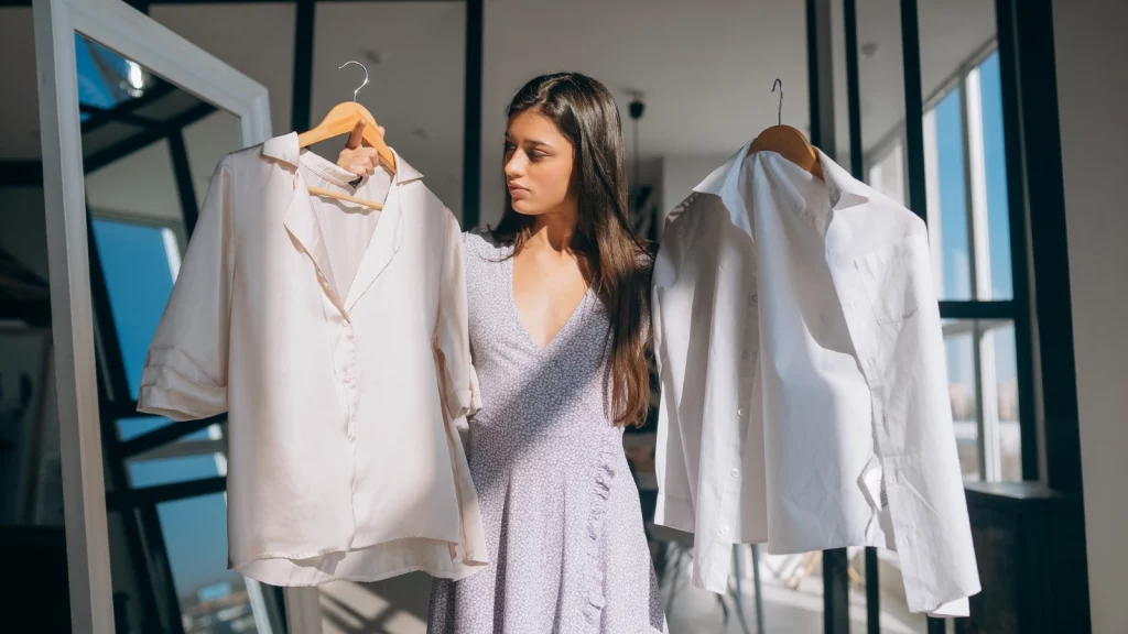 a girl holding 2 hangers