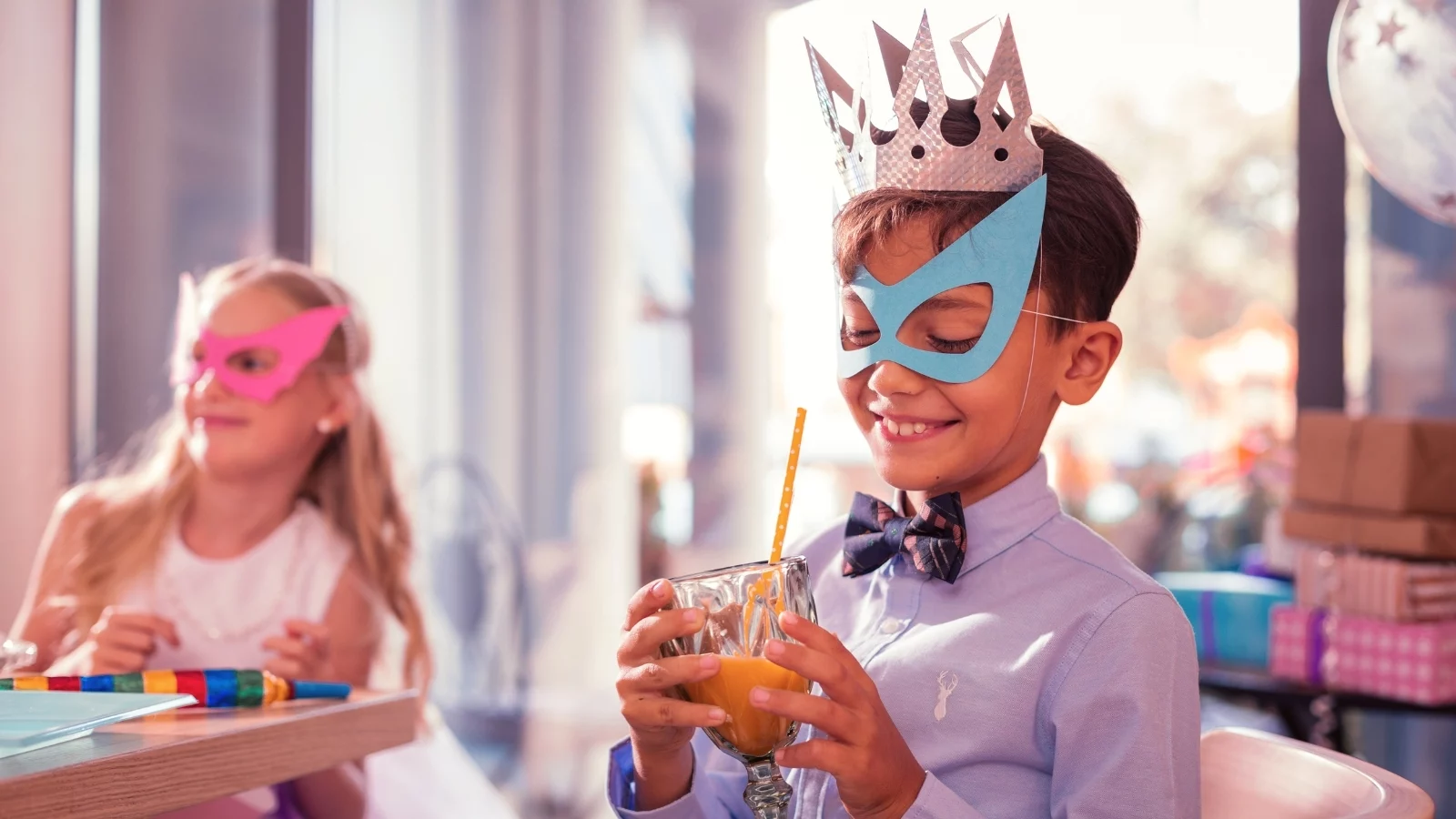 A boy wearing mask and drinking juice. 