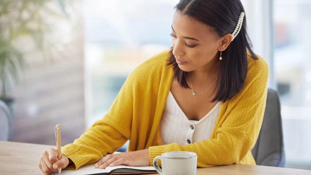 a girl writing in a journal.