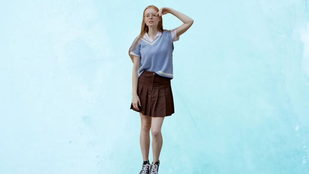 A girl wearing brown colored pleated skirt