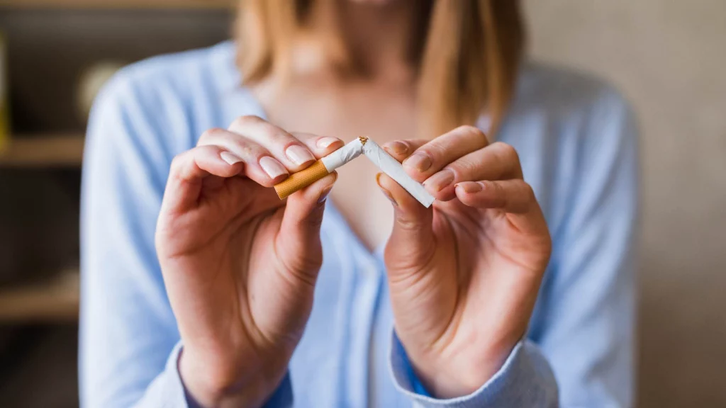 a girl breaking a cigarette.