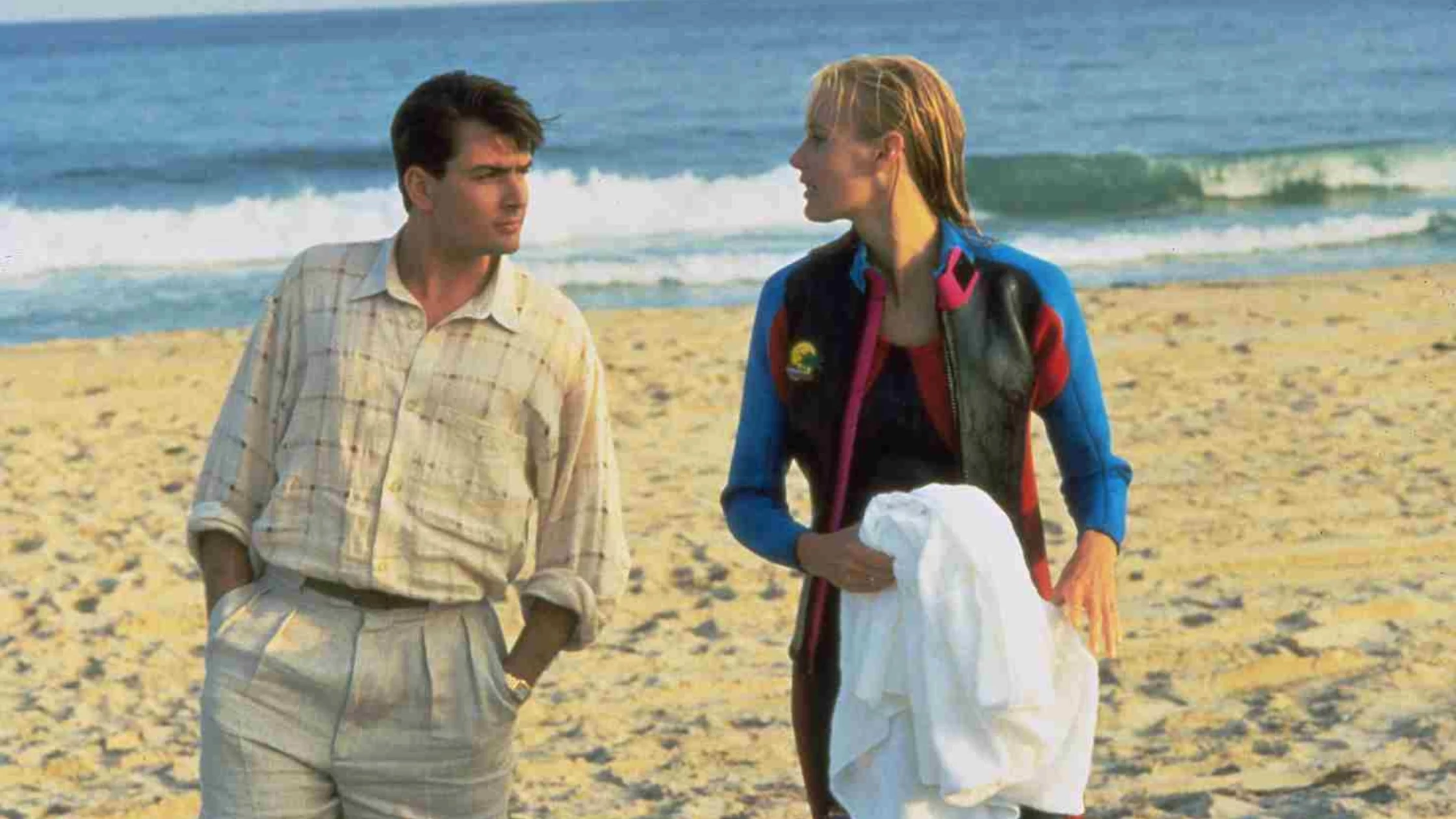 A man walking with a lady on the beach. 