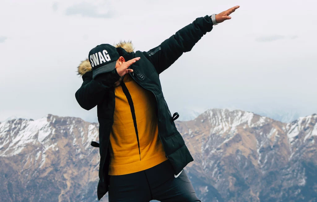 man in doing dab in mountains