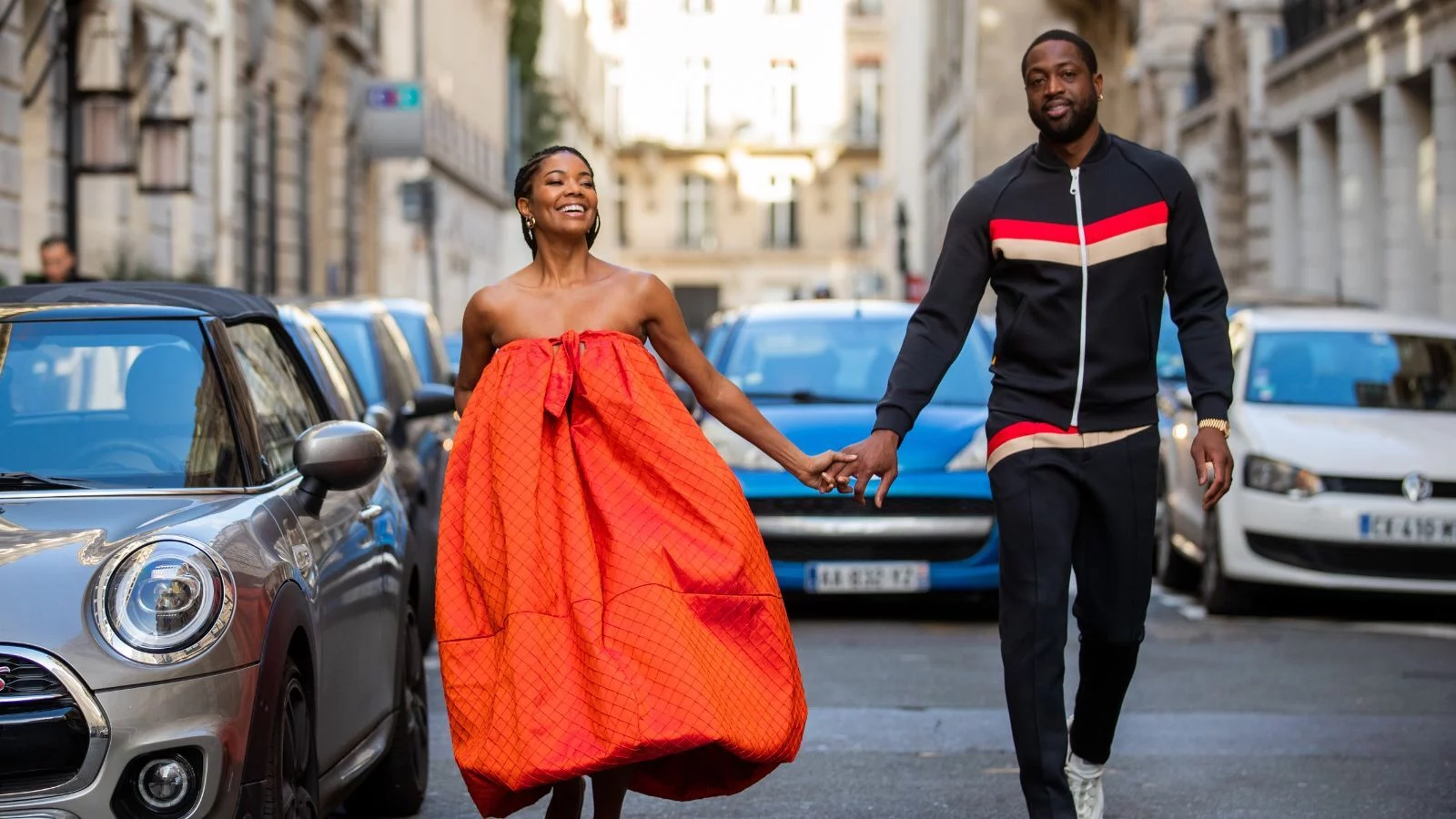 Gabrielle and Dwayne walking on a street hands in hands. 