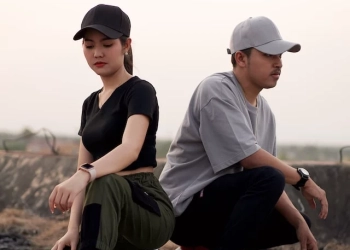 A boy and a girl posing in joggers.