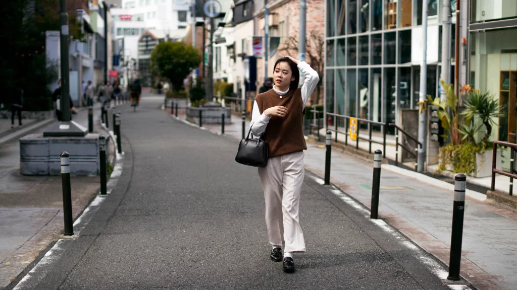 a girl wearing brown sweater on street