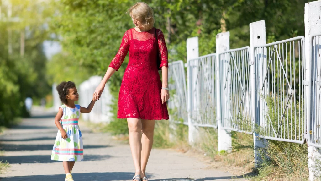 mom dressed in red walking with toddler