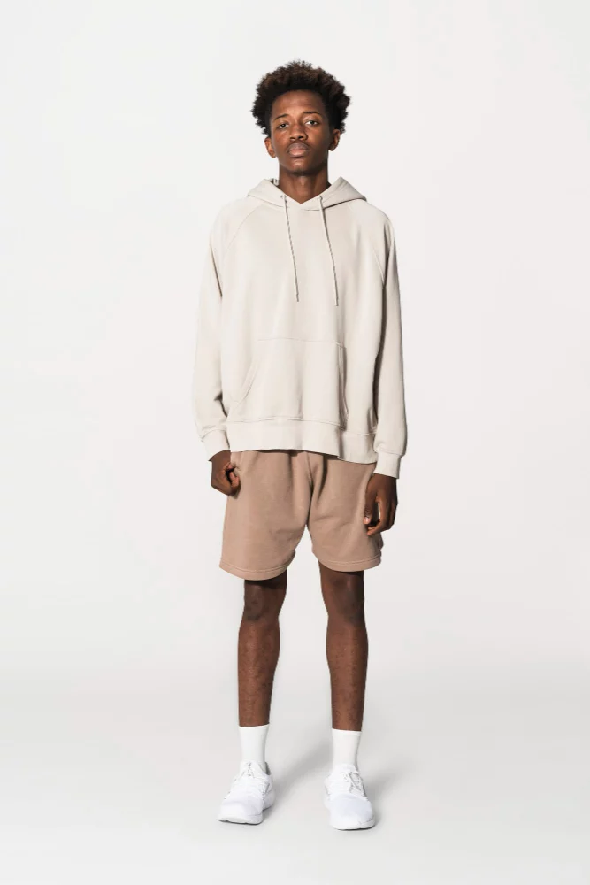A boy wearing a hoodie with shorts. 