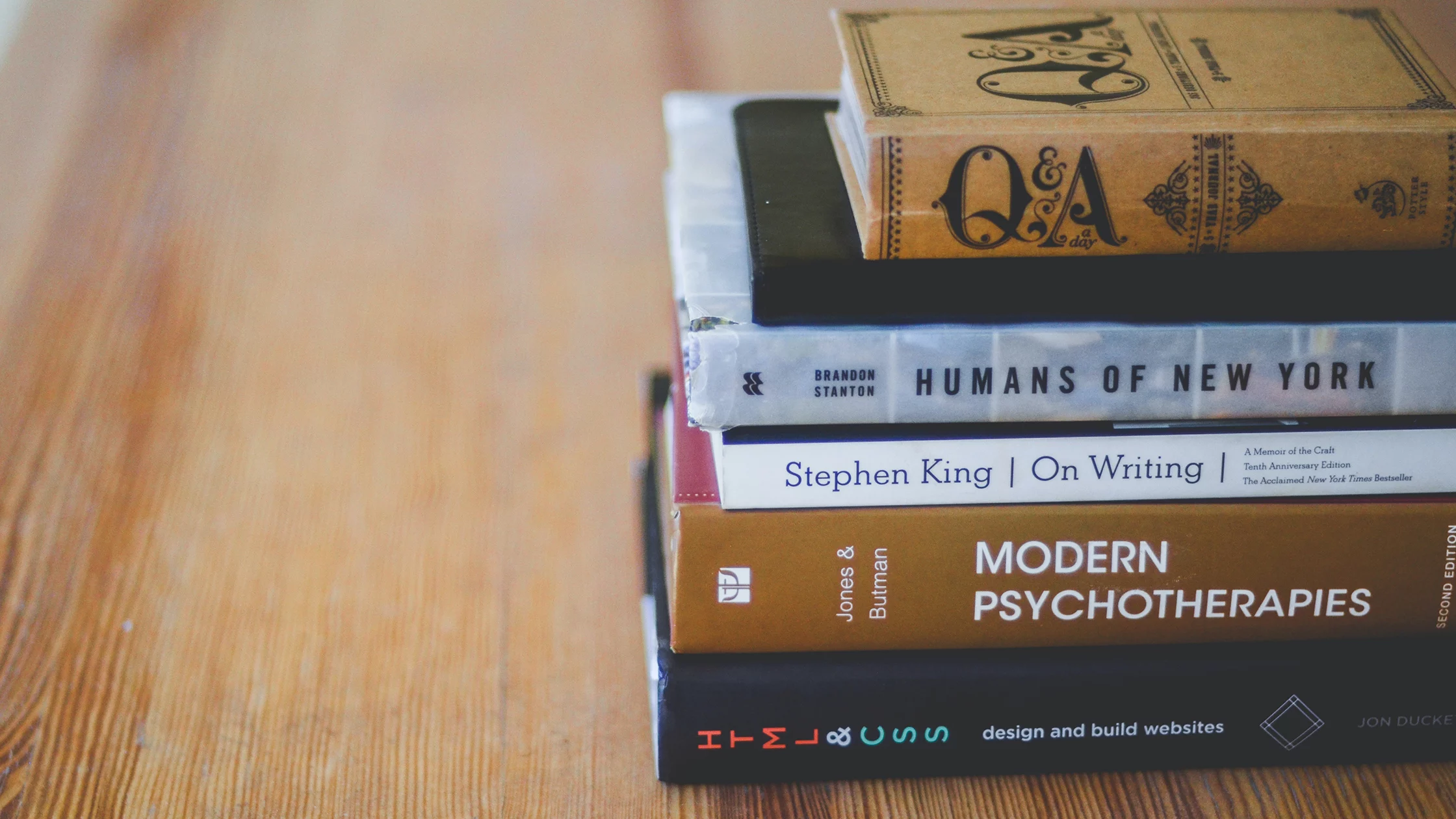 Five books lying on a table. 