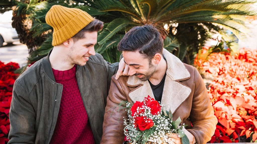 A Gay Couple holding hand and flowers