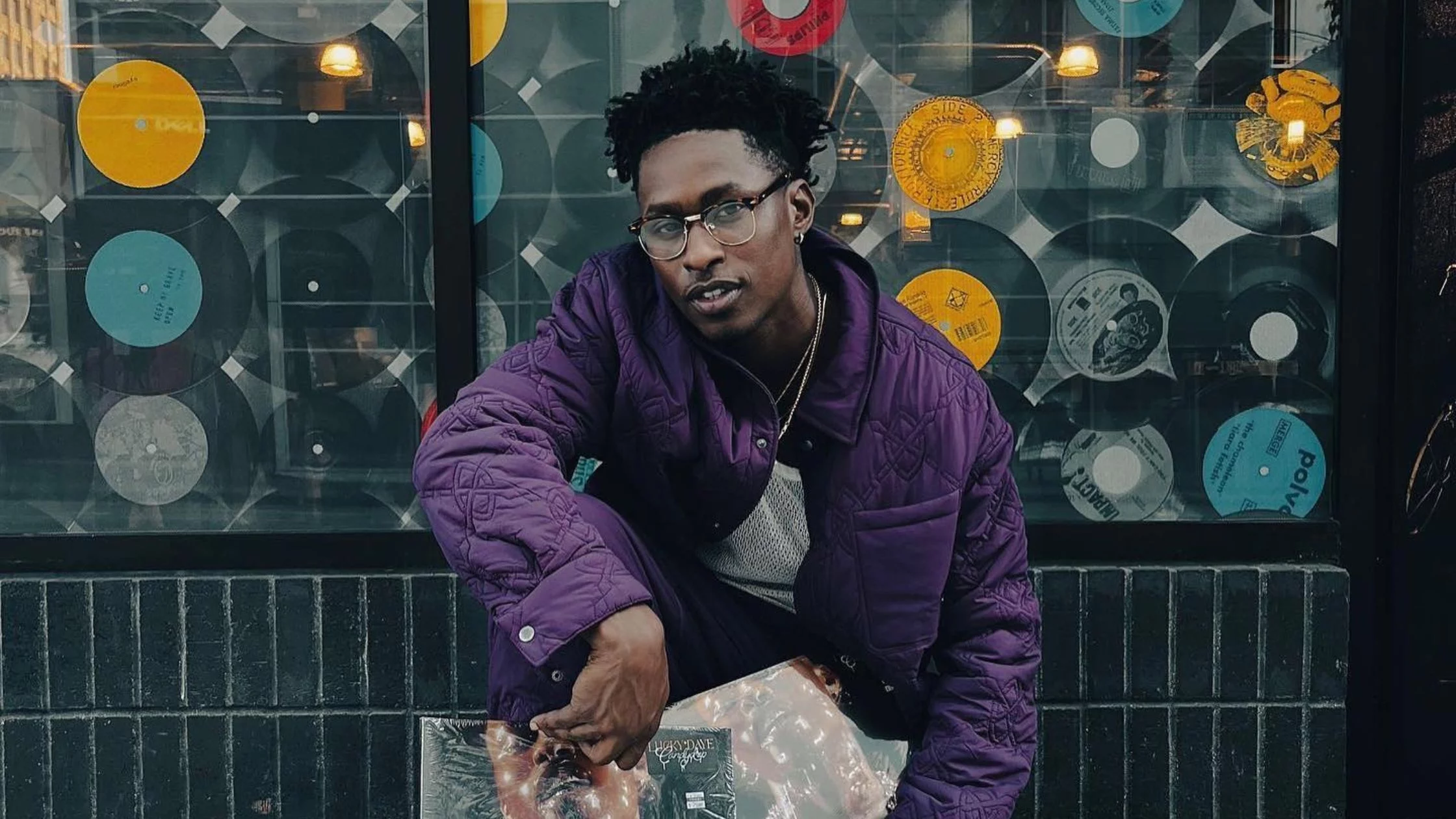 Lucky posing on the street wearing purple hoodie. 