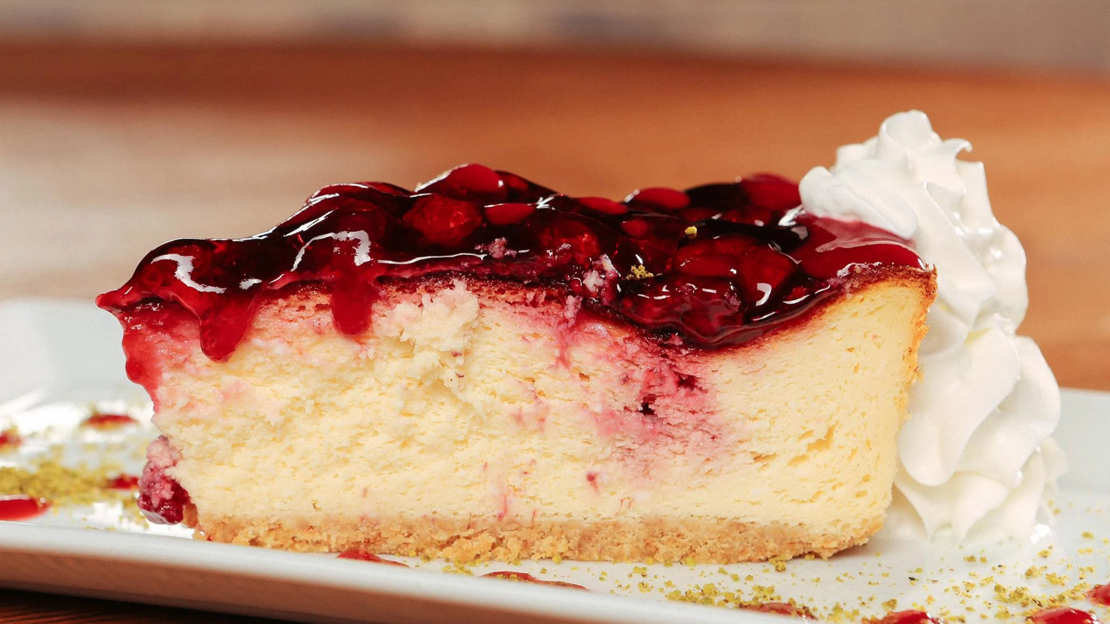 A slice of the New York Cheesecake with raspberry topping. 