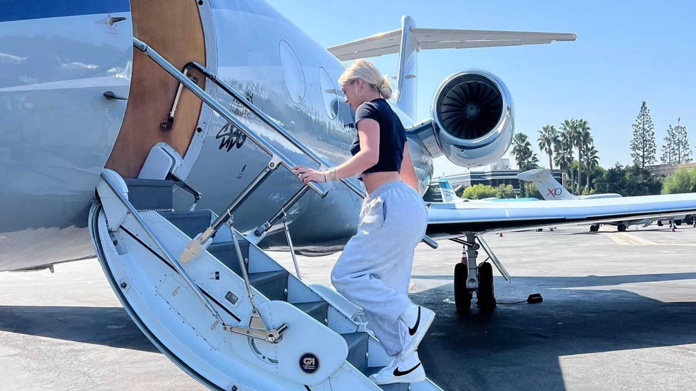Katie climbing the stairs of her private plane. 