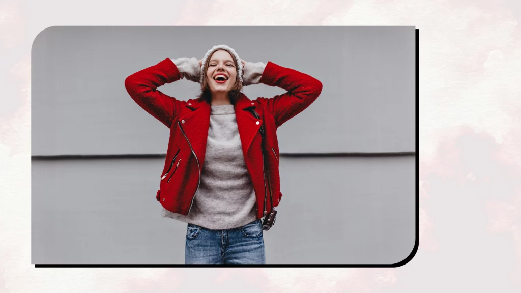 A girl wearing red colored Fleece jacket with blue jeans.