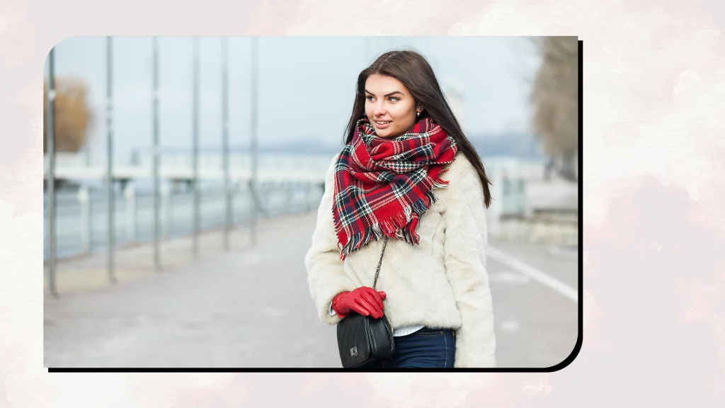 A girl wearing a scarf, white cardigan and jeans