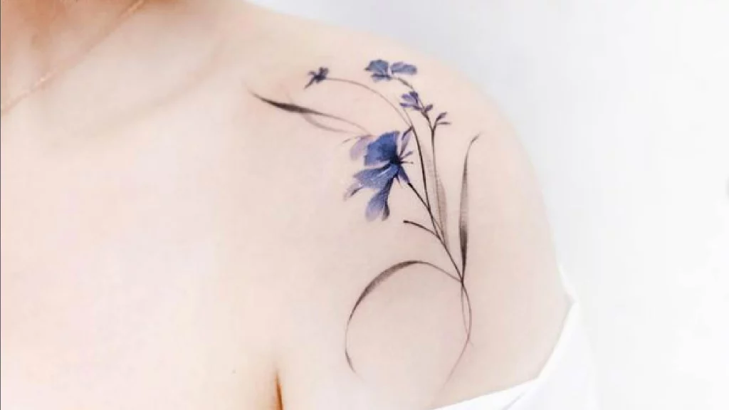 blue colored flower tattoo on shoulder.